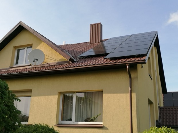 Moduliai ant rudų čerpių stogo, gyvenamasis namas