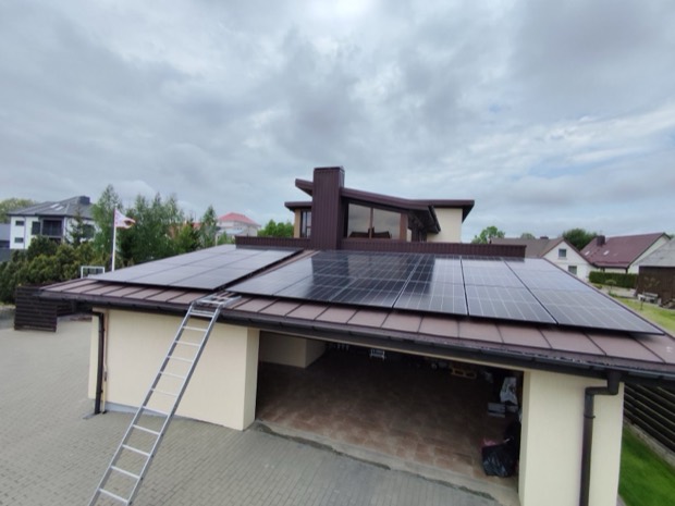 Saulės elektrinė ant modernaus namo ir garažo stogo