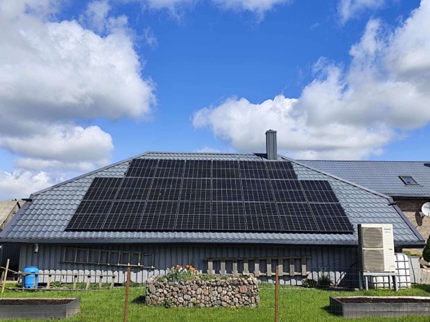 Saulės elektrinė ant pilko čerpių stogo, gyvenamasis namas