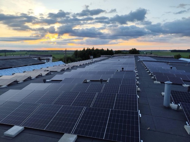 Saulės elektrinė ant pramoninio pastato plokščio stogo vakaro saulėje